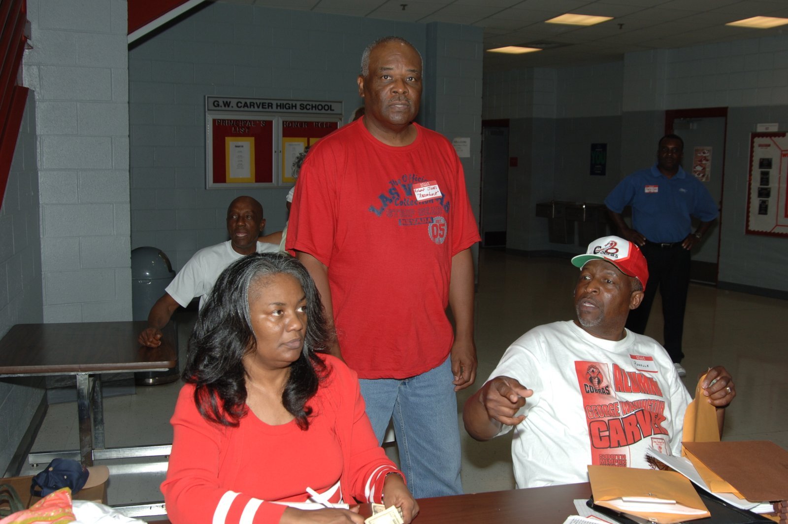Alumni at school gathering with red and white decorations