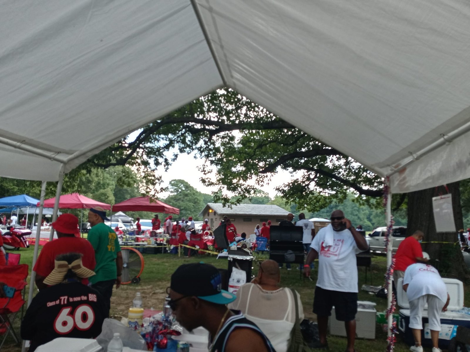 Alumni group at outdoor reunion gathering under tent