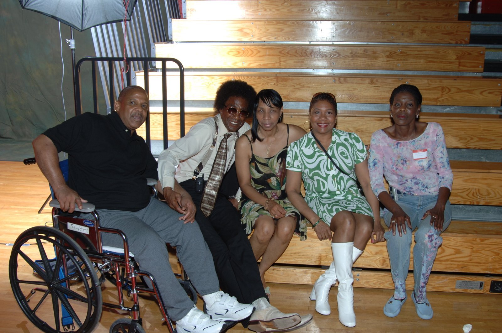 Alumni group seated on bleachers at school gymnasium