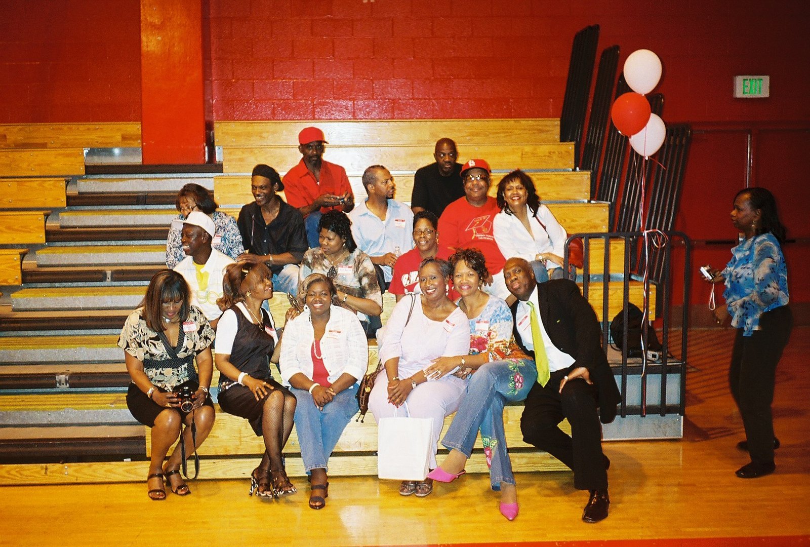 Alumni group at school gymnasium event on bleachers