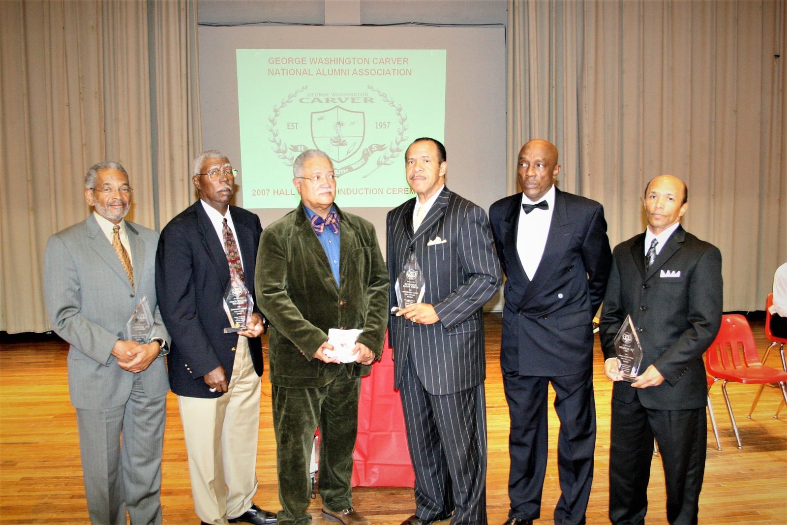 Alumni men in formal business suits at hall of fame induction ceremony