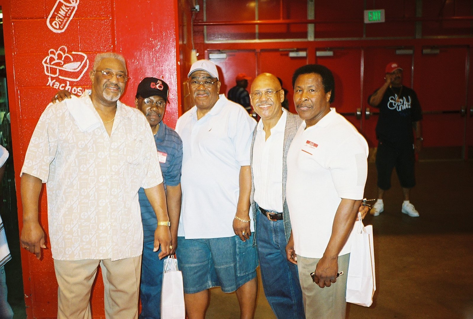 Alumni men at school event with red wall background