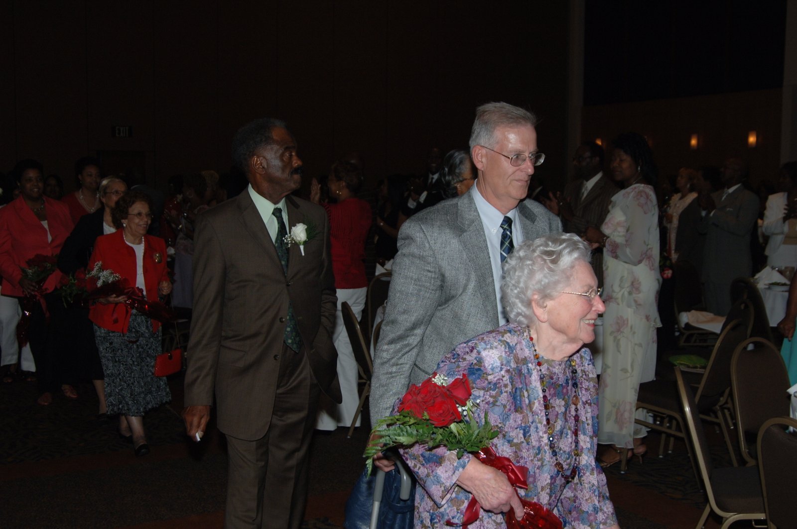 Alumni at formal event with red flowers