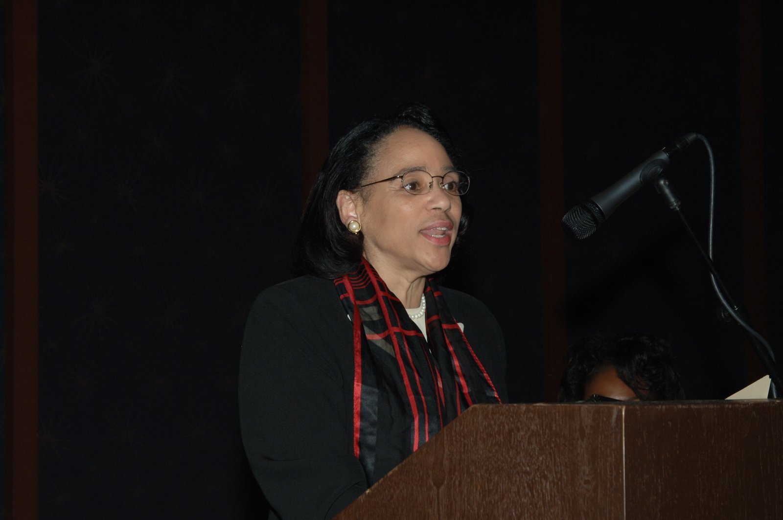 Alumni woman speaker at podium at formal event