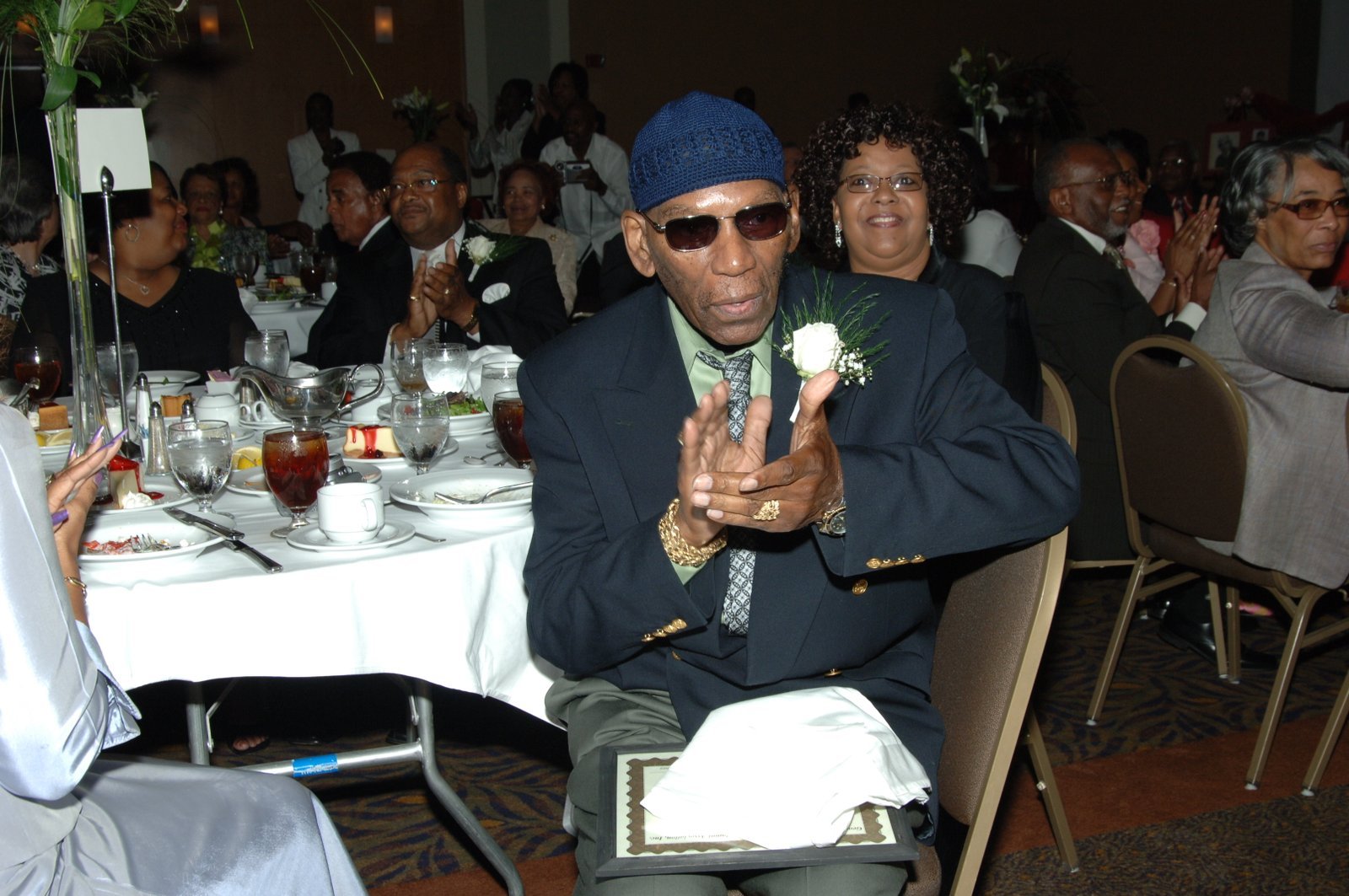 Alumni man at formal banquet event with flowers and certificate