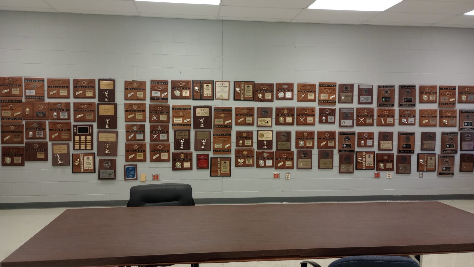 Wall display of championship plaques and awards