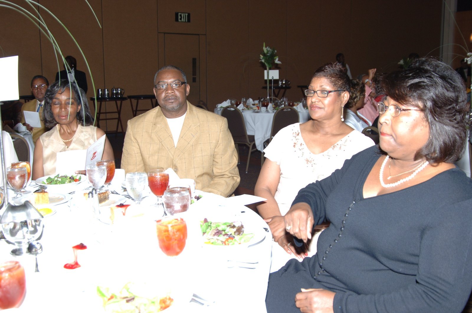 Alumni at formal dinner event with table settings and flowers