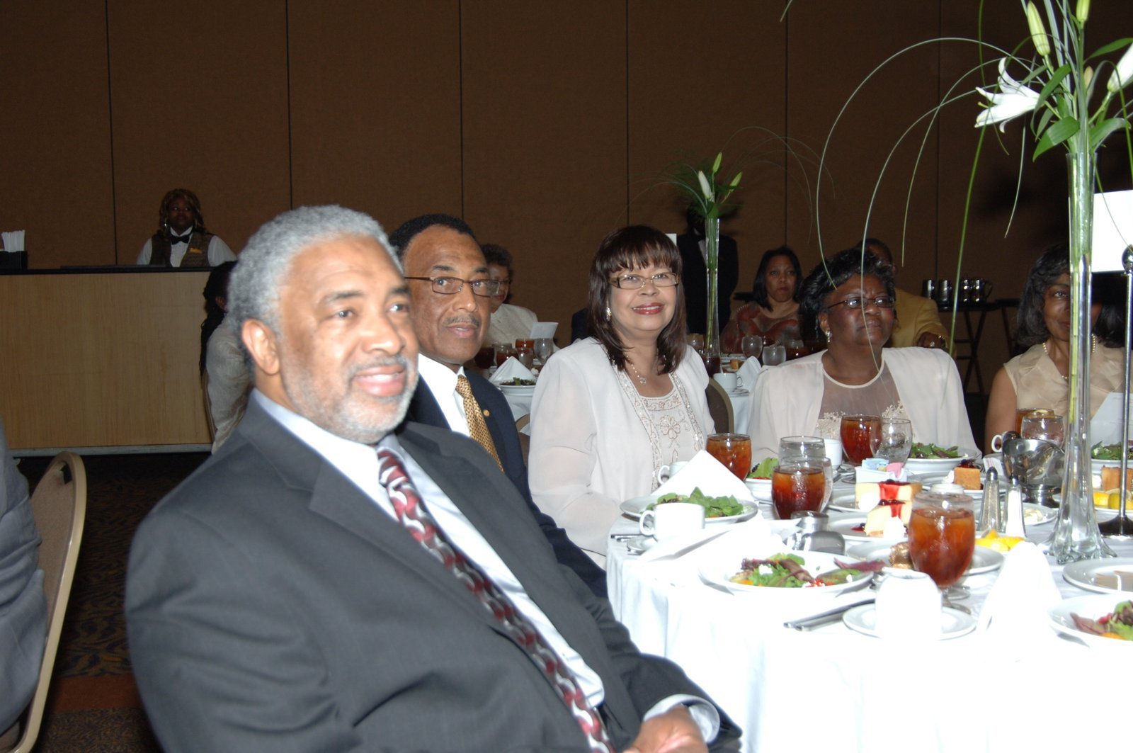 Alumni at formal event with white tablecloths and elegant decor
