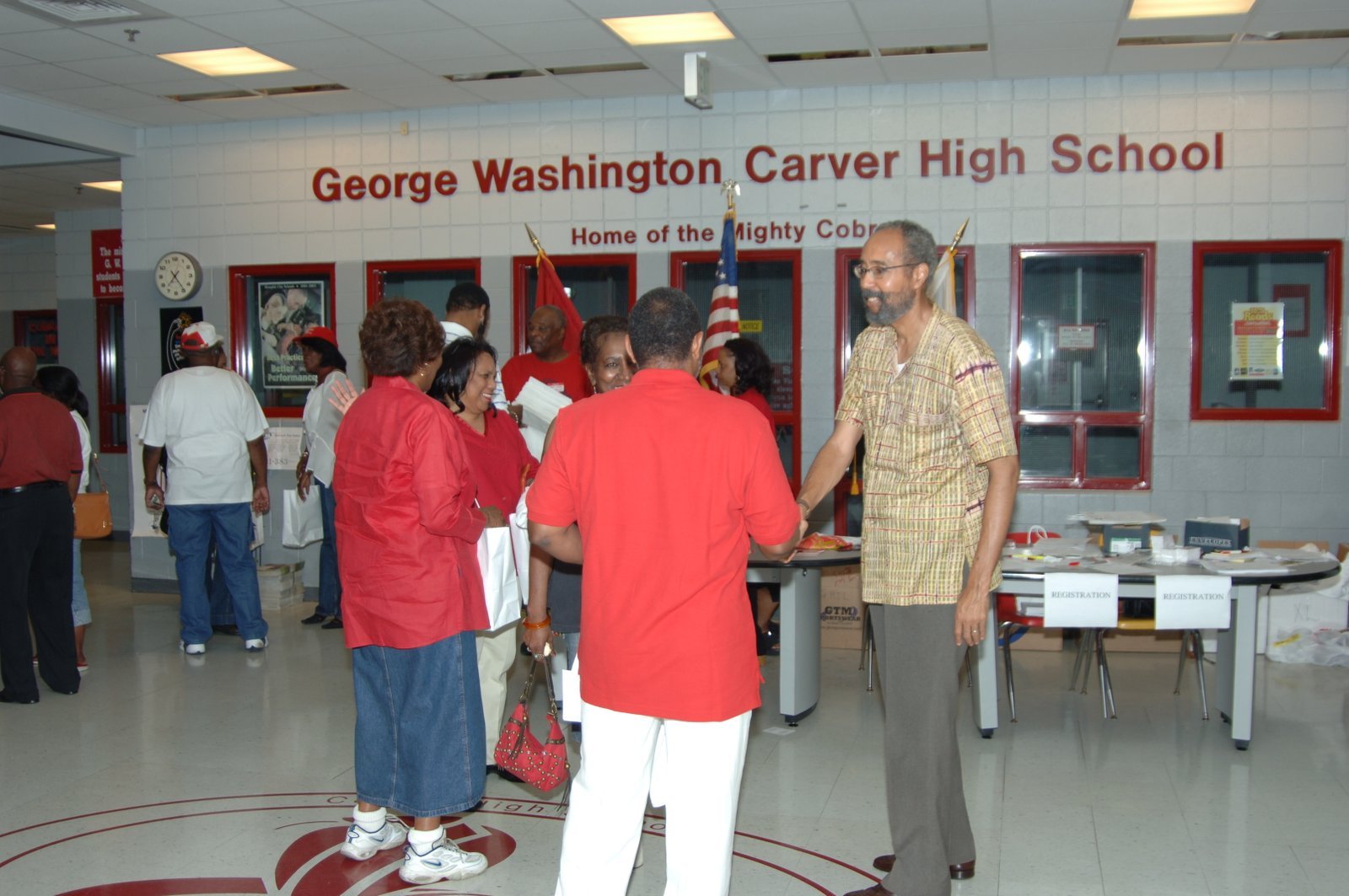 Alumni at school hallway event with red and white theme