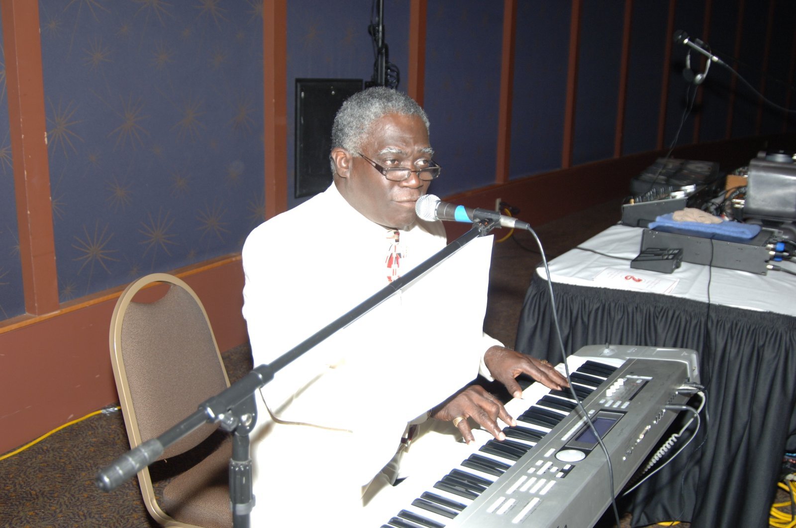 Alumni at formal event with musician performing at keyboard