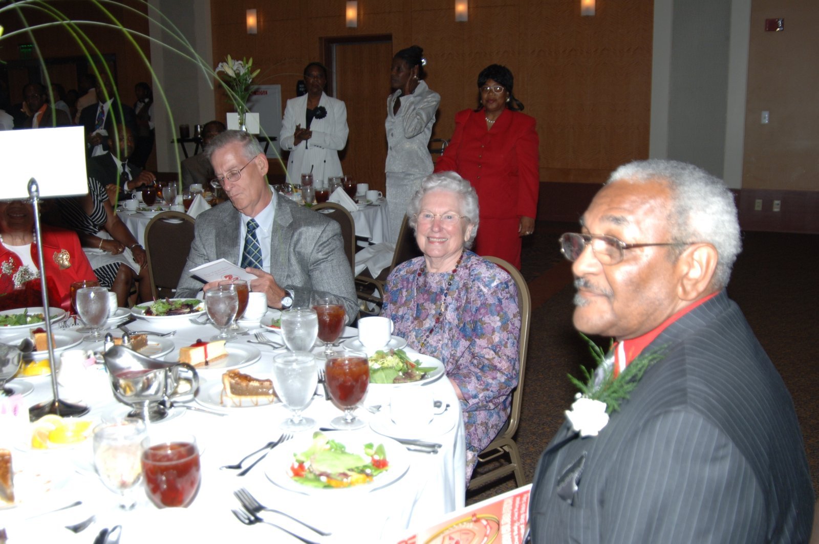 Alumni at formal banquet dinner with white tablecloths and flowers