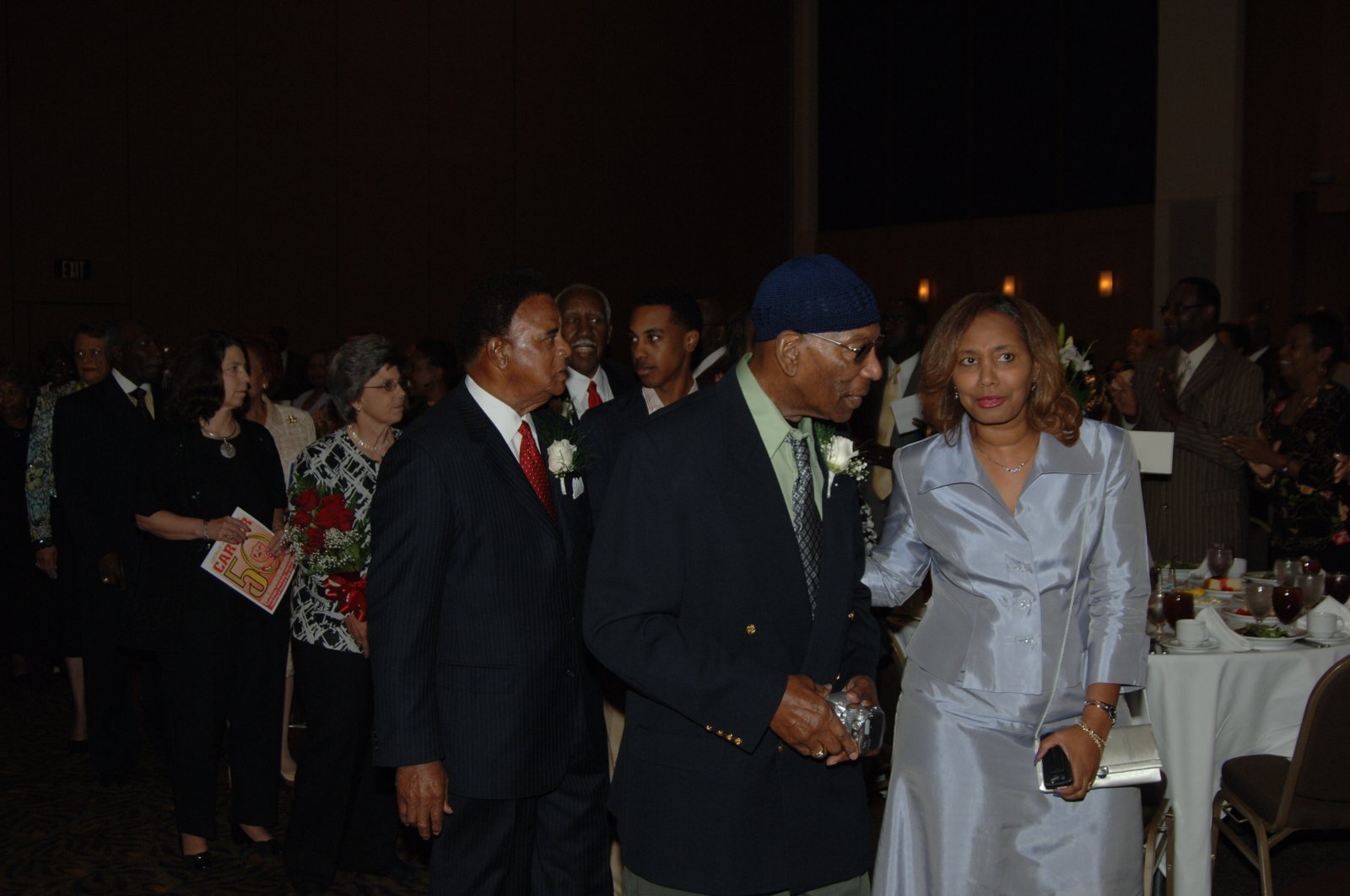 Group of people at formal event with men in suits and women in formal attire