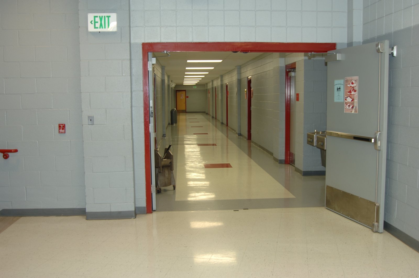 School hallway with EXIT sign and glass doors