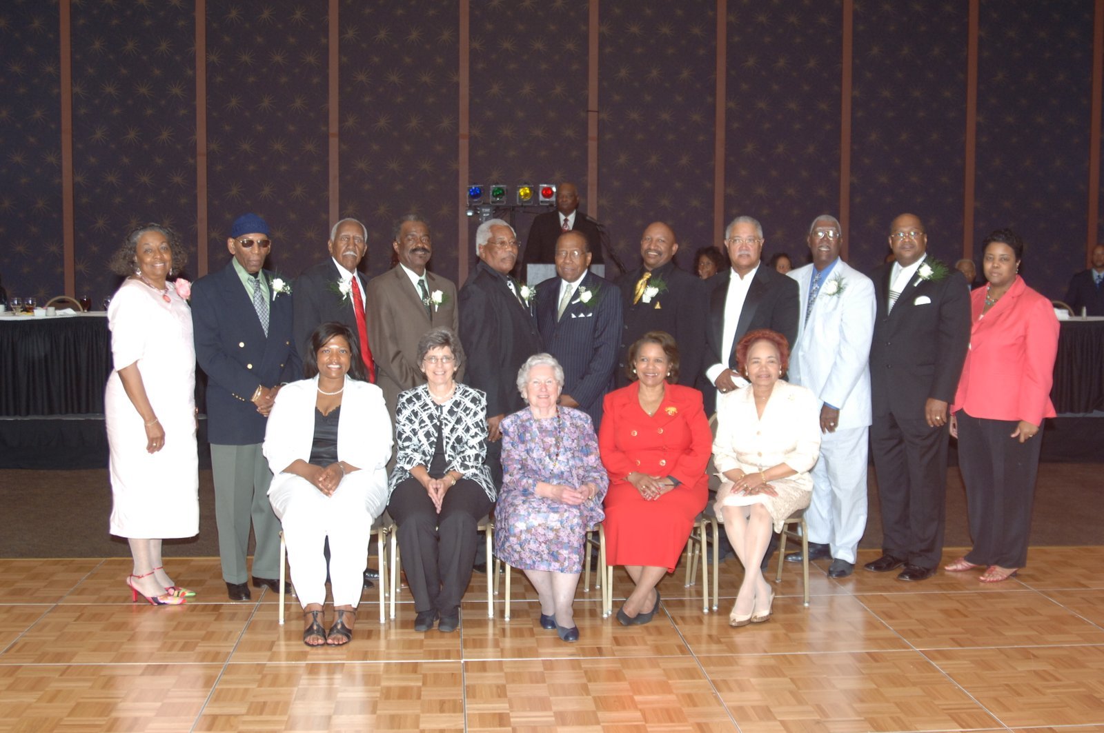 Formal group photo of smiling alumni gathered indoors