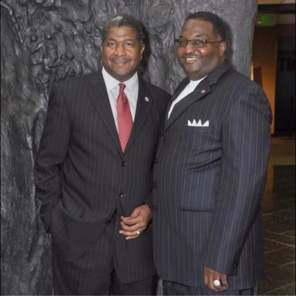 Two alumni men in formal business attire