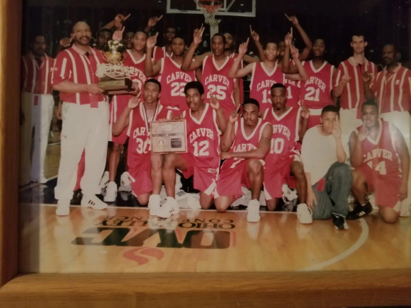 Carver basketball team in red jerseys with trophy